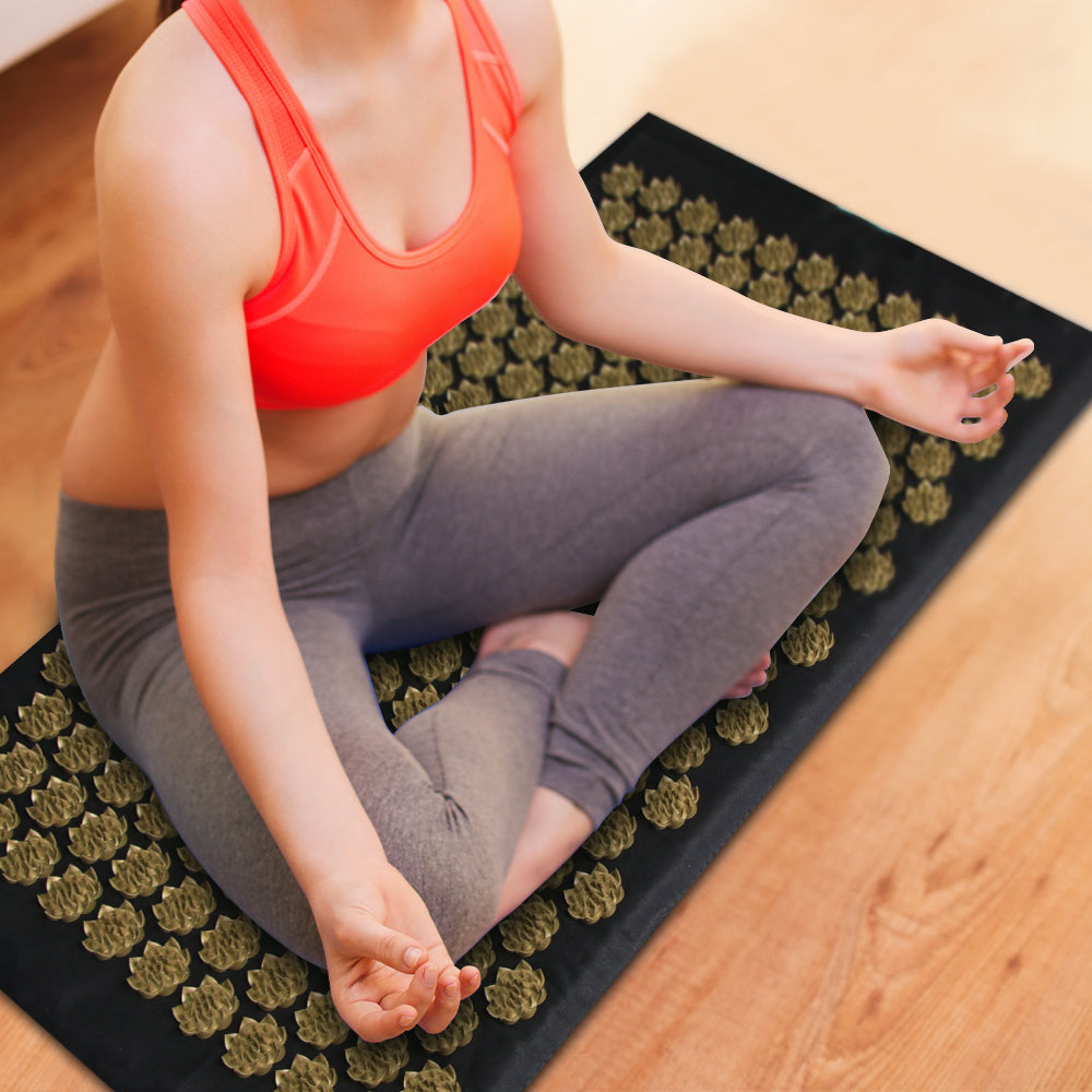Détail des points d’acupression sur tapis noir et or pour stimulation musculaire et détente