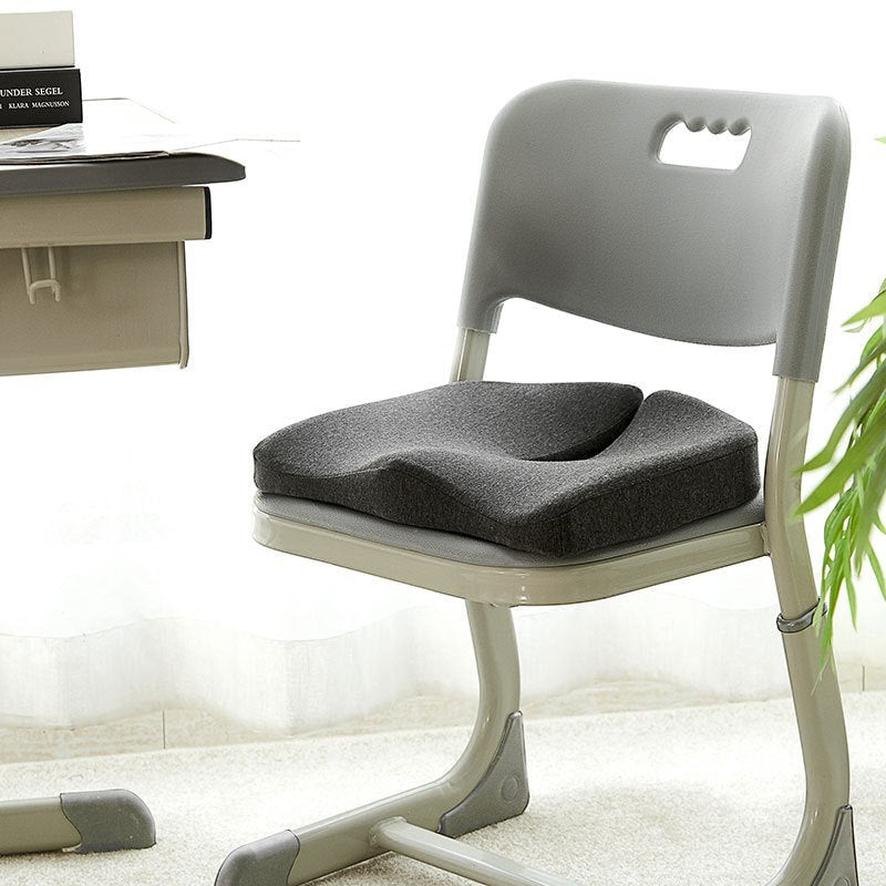 Coussin d'assise ergonomique Reprogrammer Boutique em espuma de memória cinzenta, com recorte para o cóccix, para conforto prolongado.